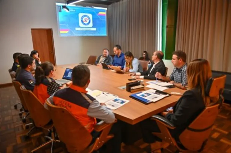 Membros do comitê de gerenciamento de crise reunidos para planejamento de ações preventivas contra eventos climáticos.